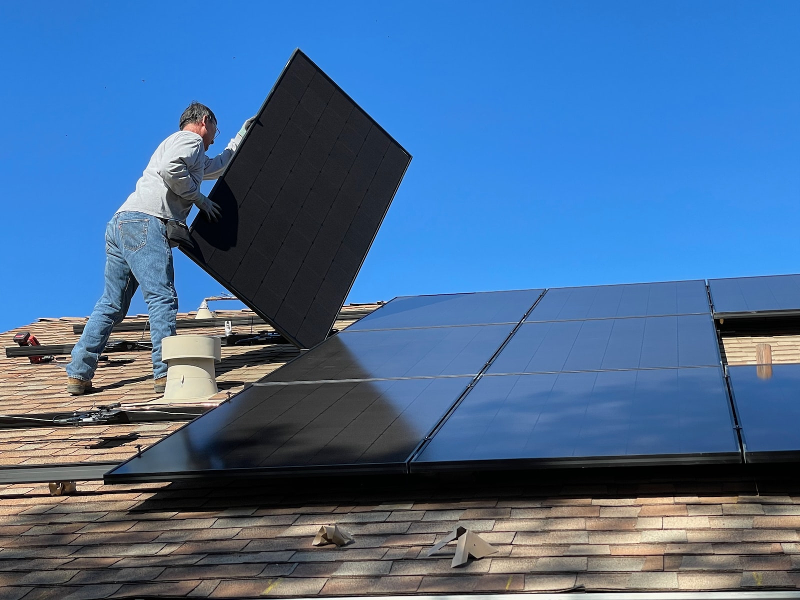 Mann som installerer solceller på et tak i Bergen